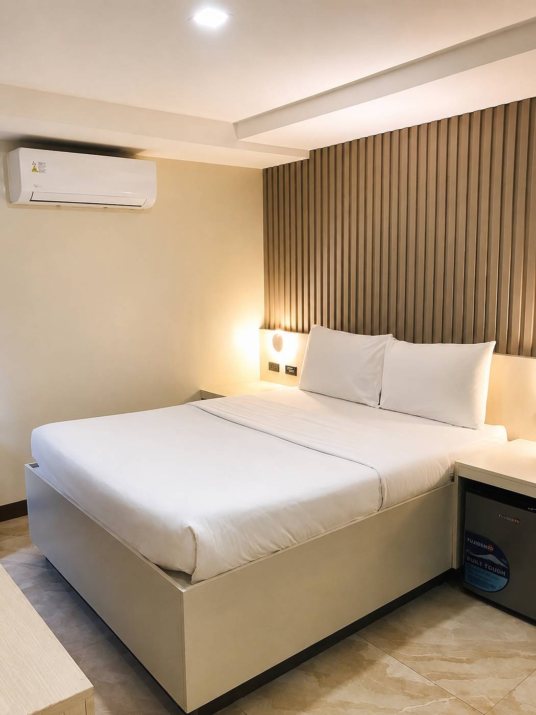 Air-conditioned room with a double bed and warm lighting